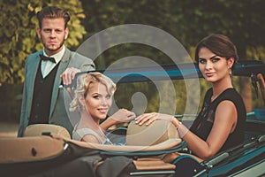 Wealthy young friends in a classic convertible