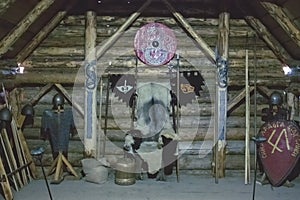 Weapon of the ancient knights sword, axes stand on the background of a wooden wall