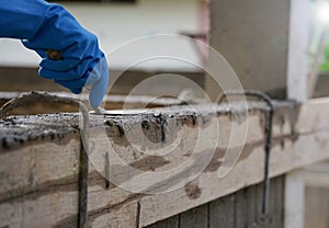 Wear glove hand of industrial bricklayer hold  aluminium brick trowel installing mortar wall on construction site