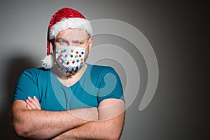 Wear a mask. Adult man in Christmas decorated mask celebrate xmas holidays at home because coronavirus.