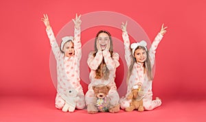Wear pyjamas to celebrate. Surprised girls give v-signs in pyjamas. Pajama party. Homewear for kids