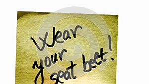 Wear seatbelt handwriting text close up isolated on yellow paper with copy space