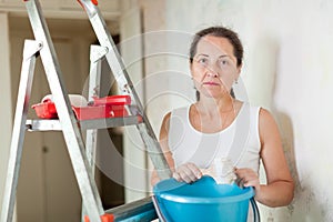 Weariness woman makes repairs at home