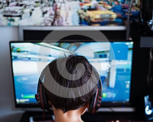 Wearing headphone, A gamer or a streamer boy at home in a room playing with friends on the networks in video games