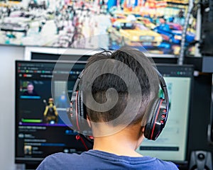 Wearing headphone, A gamer or a streamer boy at home in a room playing with friends on the networks in video games