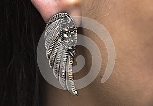 Wearing a silver metal wing earing photo