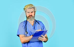 He is wearing a stethoscope. nurse holding binder and wearing stethoscope. mature bearded male doctor with a folder in