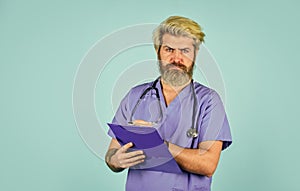 he is wearing a stethoscope. nurse holding binder and wearing stethoscope. mature bearded male doctor with a folder in