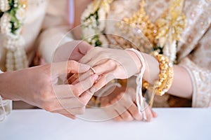 Wearing a wedding ring, The groom wears a wedding ring on the bride`s finger. Wedding ring exchanges in Thailand