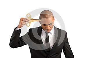 Weary businessman recharge himself with a key due to overwork