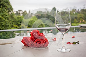 weary rose bouquet and red wine left after party