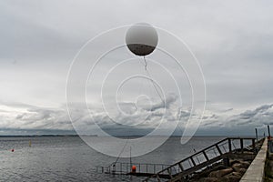 Weather balloon flies on the sea near the haven of Aarhus