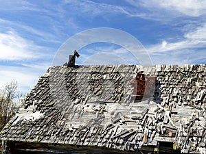 Weather cabin rook with shingles and a red brick chimney