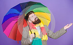 Weather forecast concept. Man bearded hipster hold colorful umbrella. It seems to be raining. Rainy days can be tough to