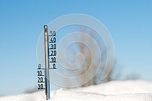 Weather forecast. Thermometer on snow show low temperature. Blue sky. Meteorology photo