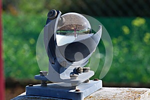 Weather station and the sun in a blue sky reflected in the glass sphere of a beautiful heliograph o photo