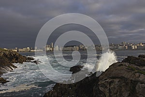 Weather, storm, the city in the background. The shore near the oken is rocky.