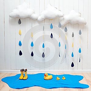 Weather symbols. Handmade room decoration clouds with rain drops, puddle, child yellow rubber boots and ducks