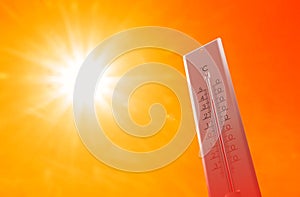 Weather thermometer with high temperature outdoors on hot sunny day. Heat stroke warning