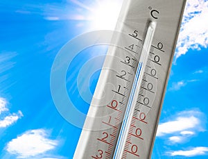 Weather thermometer with high temperature outdoors on hot sunny day. Heat stroke warning