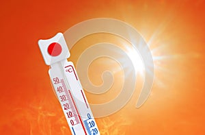 Weather thermometer with high temperature outdoors on hot sunny day. Heat stroke warning