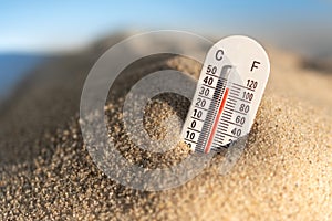 Weather thermometer with high temperature outdoors in the sand