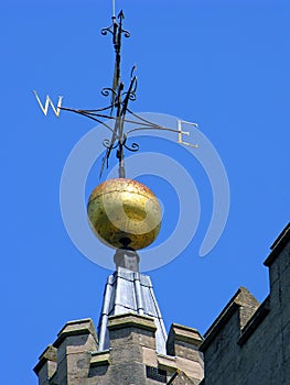 Weather vane, on a golden ball, at the top of a stone tower