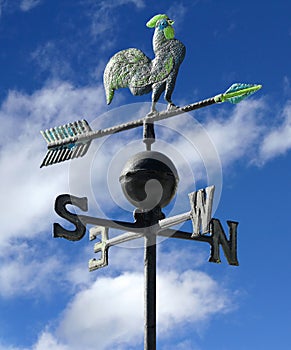 weather vane to indicate the wind direction with a rooster in wrought iron and arrows