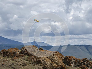 Weather vane, wind designator against the blue mountains photo