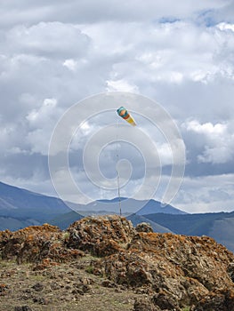 Weather vane, wind designator against the blue mountains photo