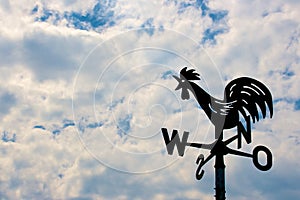 Weathercock on cloudy sky photo