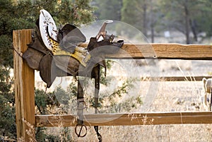 Weathered Antique Saddle on Fence photo