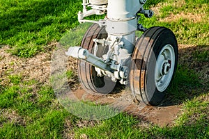 Weathered aviation landing gear rusting in a field showing signs of neglect