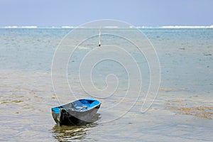 Weathered blue canoe floating in the Sea off the coast of Roatan