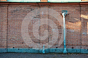Weathered brick wall with a rusty metal drainpipe