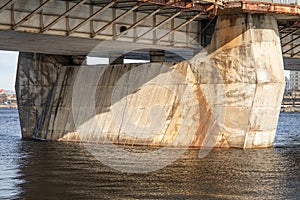 Weathered Bridge Support Structure with Concrete Base and Rusty Metal Beams photo