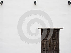 Weathered Brown Wooden Door on White Building