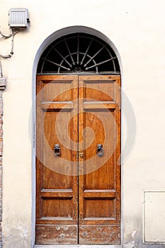 Brown wooden doors in a stone archway wall