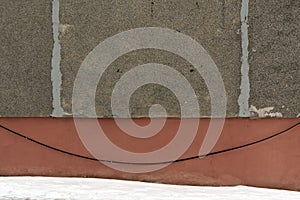 Weathered cement wall and pile of snow.