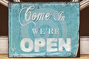 Weathered come in we're open sign photo