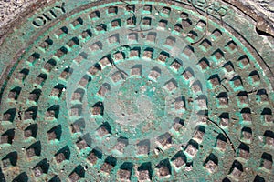 Weathered copper stained manhole cover