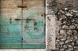 Weathered door with fading, turquoise paint