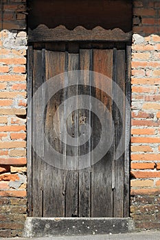 Weathered Gray Door in a Brick Wall