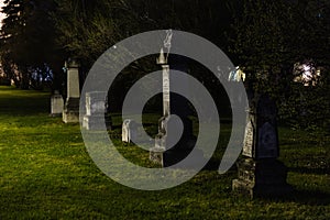 Weathered headstones at night time