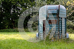 Weathered horsebox standing in a meadow
