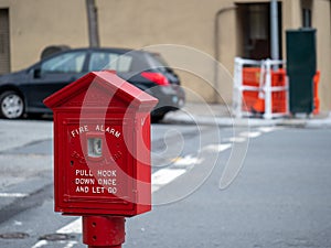 Weathered, old red fire alarm call box on street corner outside