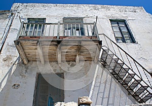 A weathered old wooden balcony, at a village house on the Greek island of Anti Paros.