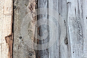 Weathered old wooden wall detail. Simple gray boards with knotholes and coarse grain nailed together. Outdoor. Backgrounds.