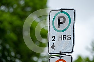 Weathered parking sign with 2-hour limit