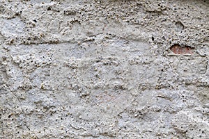 Weathered pebble dash roughly covering an old brick wall. Abstract background design texture